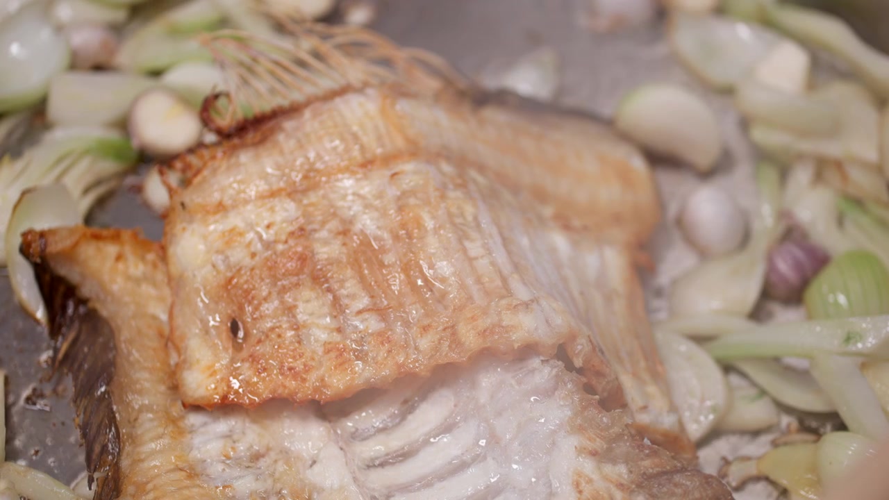 In der Pfanne brutzelnd, landet der Fisch im heißen Öl, goldbraun