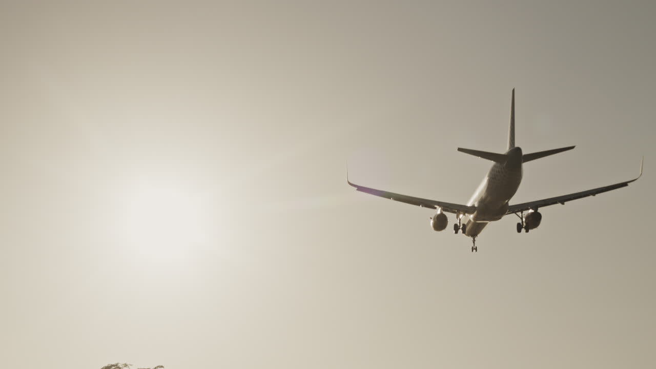 Avión volando en el cielo para aterrizar en el aeropuerto a cámara superlenta al atardecer