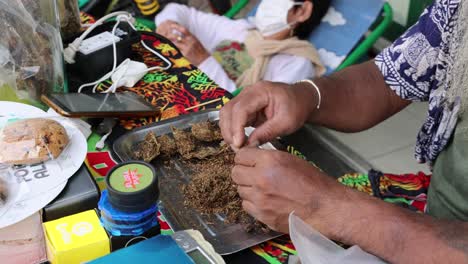 hands preparing tobacco with cultural artifacts