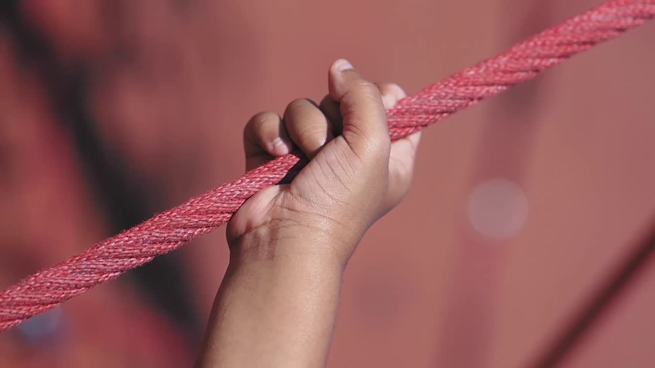 Hand holding a red rope