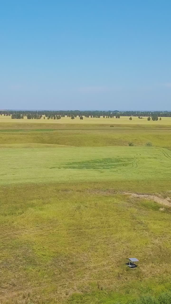 tranquil lake and wide green field under boundless clear blue sky on nice autumn day aerial panorama