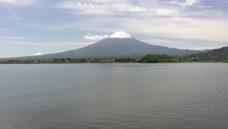 Luftaufnahme-Tief-über-Dem-Kawaguchi-See-Mit-Spiegelung-Des-Fuji-Im-Wasser,-Malerischer-Landschaft-Und-Schneebedecktem-Gipfel-An-Einem-Klaren,-Sonnigen-Tag-In-Fuji,-Japan