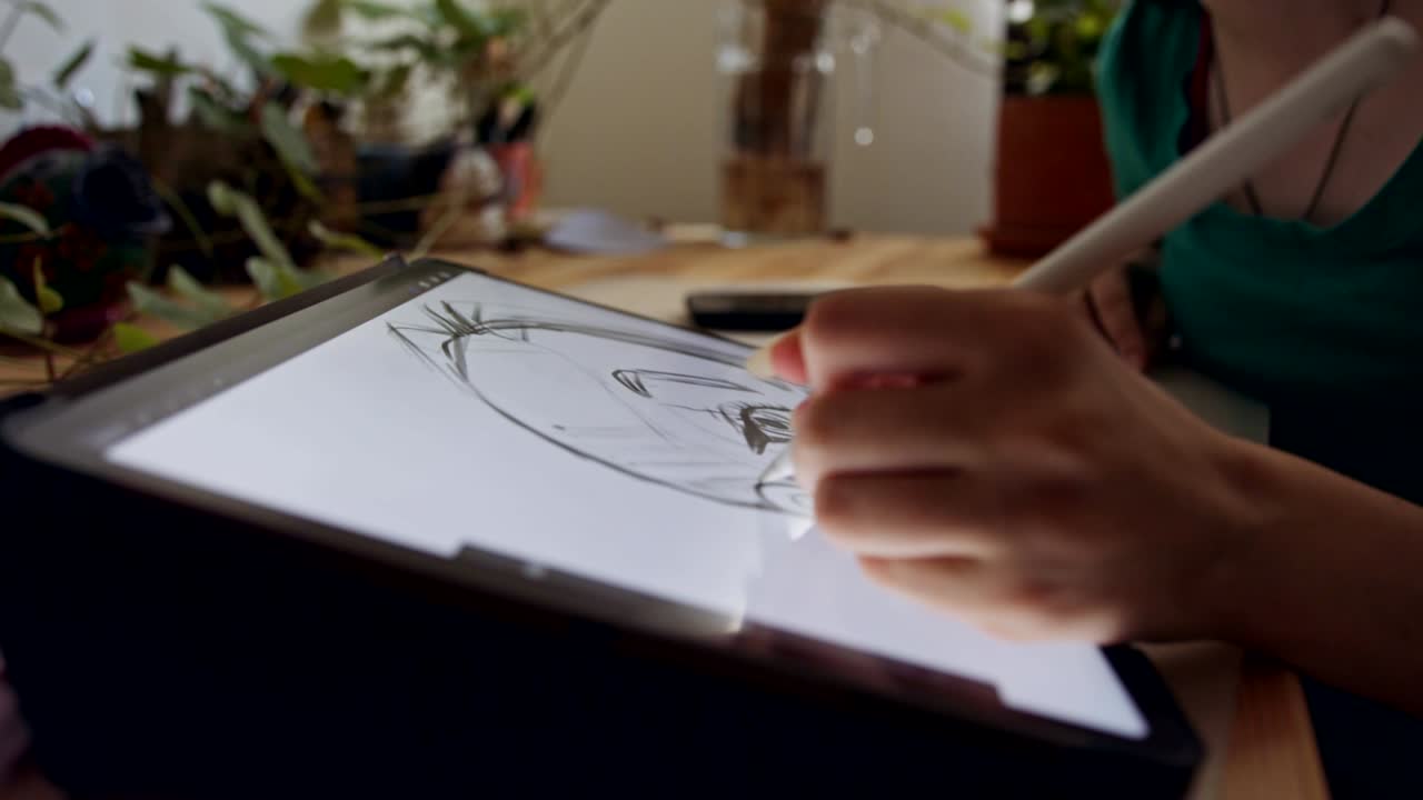 십대 소녀가 태블릿 컴퓨터와 전자 펜을 사용하여 그림을 그리고 있습니다.