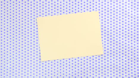 yellow piece of paper on a dotted background with oranges around it