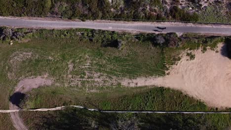 Tilt-up-view-of-former-Quinns-Rocks-caravan-park-site-showing-walkers-on-coastal-path-and-sand-dunes-in-background