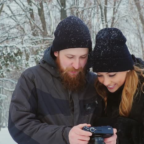 young couple viewing photos on camera in winter