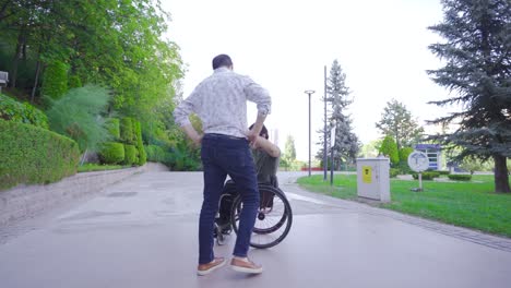 happy young man in wheelchair having fun with his friend.