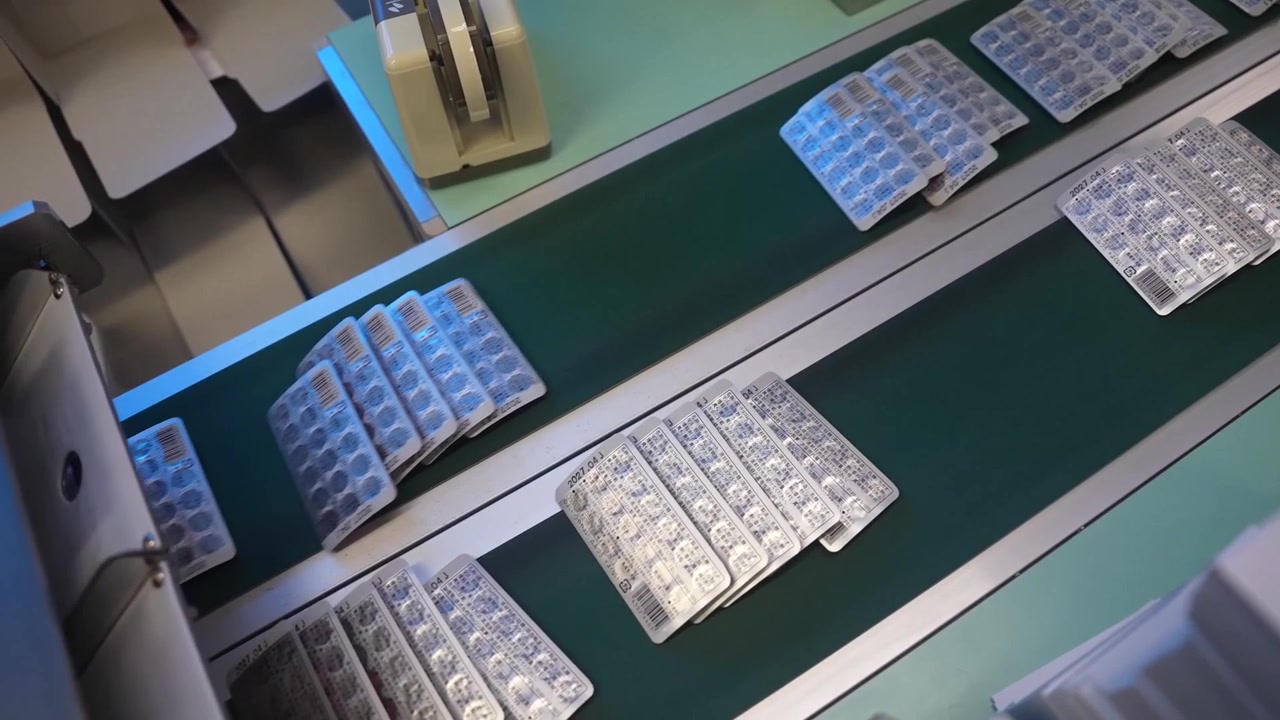 Empty and filled blister trays travelling through a blister packaging machine
