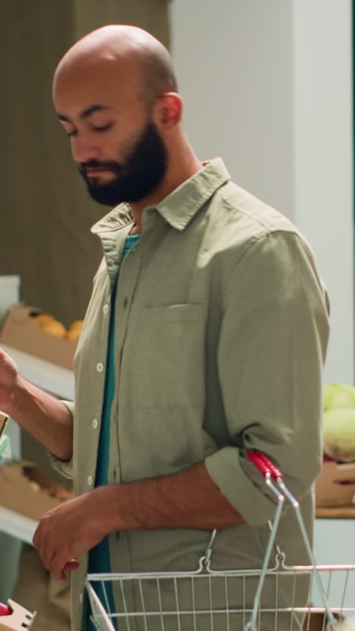Cliente che guarda cetrioli biologici in video verticale