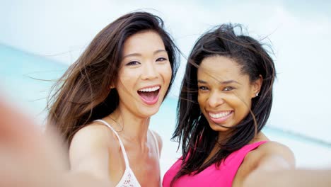 portrait of multi ethnic girlfriends on ocean sand