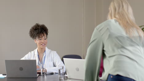 diverse doctors using laptops in meeting room with copy space, slow motion