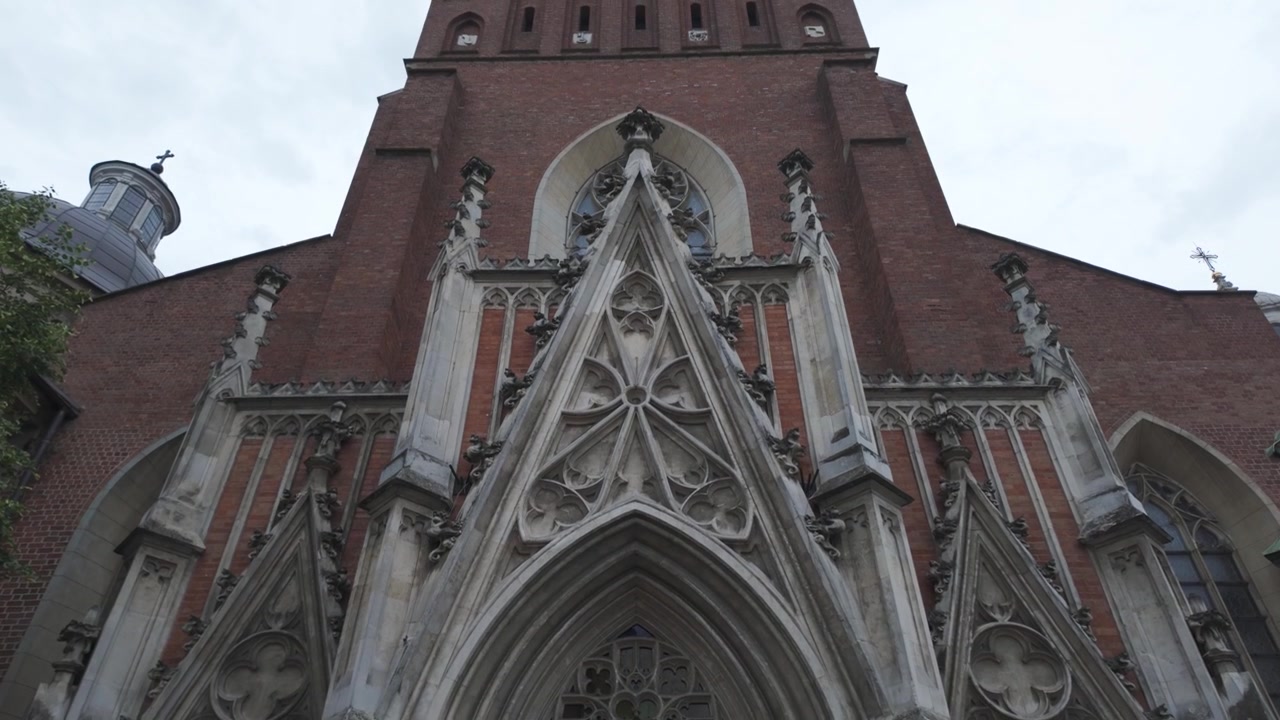 Ingresso in pietra intagliata della Chiesa della Santissima Trinità a Cracovia, che mostra la sua architettura gotica e l'esterno storico.