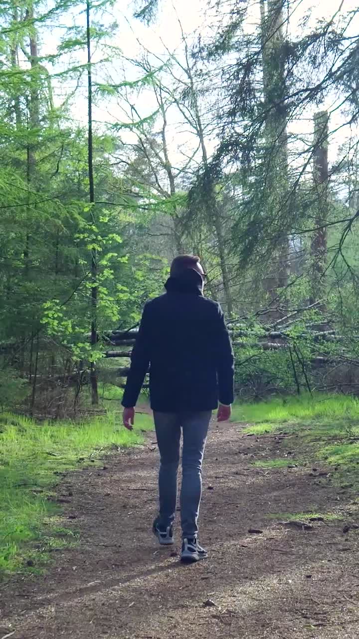 hombre caminando por un sendero forestal