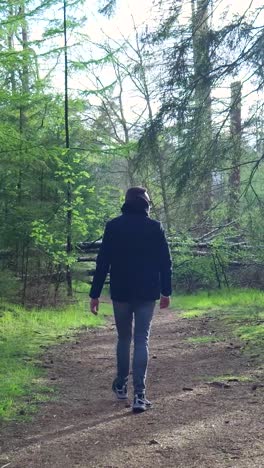 man walking through a forest path