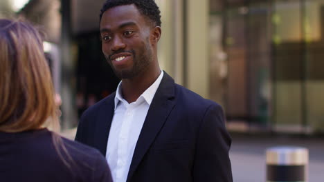 Businessman-And-Businesswoman-Shaking-Hands-Outside-Offices-In-The-Financial-District-Of-The-City-Of-London-UK-1