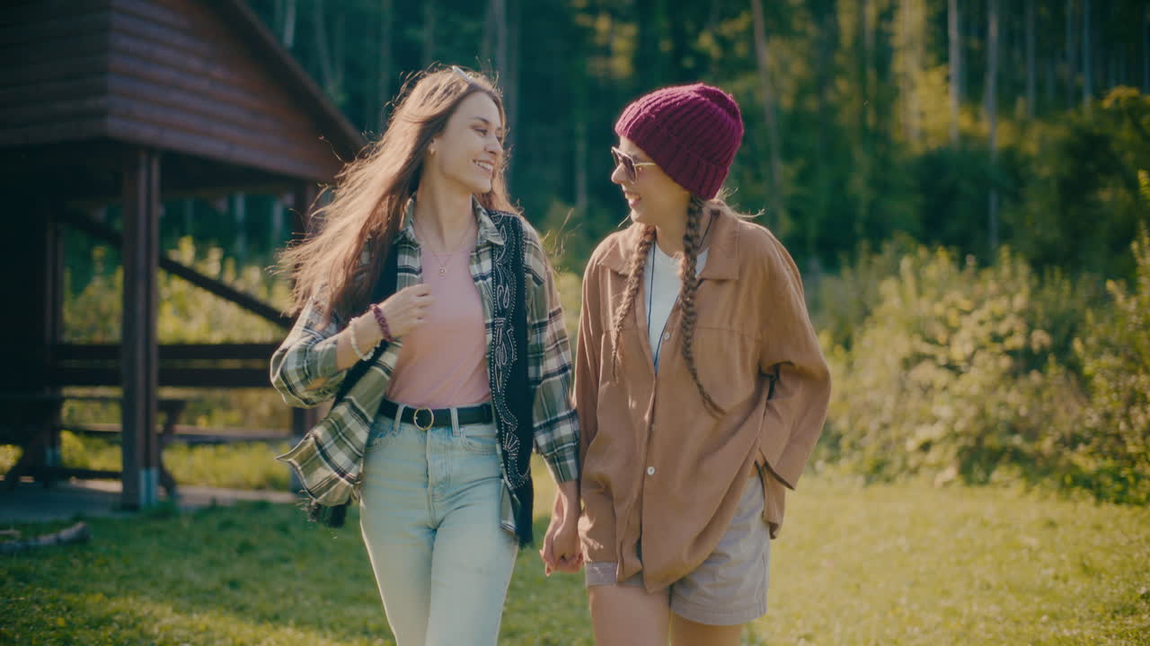 森で目覚めながら手をつないでいる幸せな女性友達