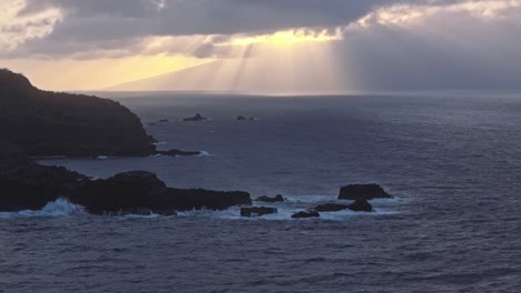 los rayos del sol rompiendo a través de las nubes sobre la costa noroeste de maui, hawai al amanecer