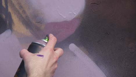 persona pintando graffiti en una pared