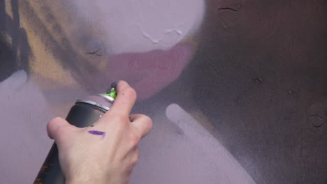 person spray painting graffiti on a wall