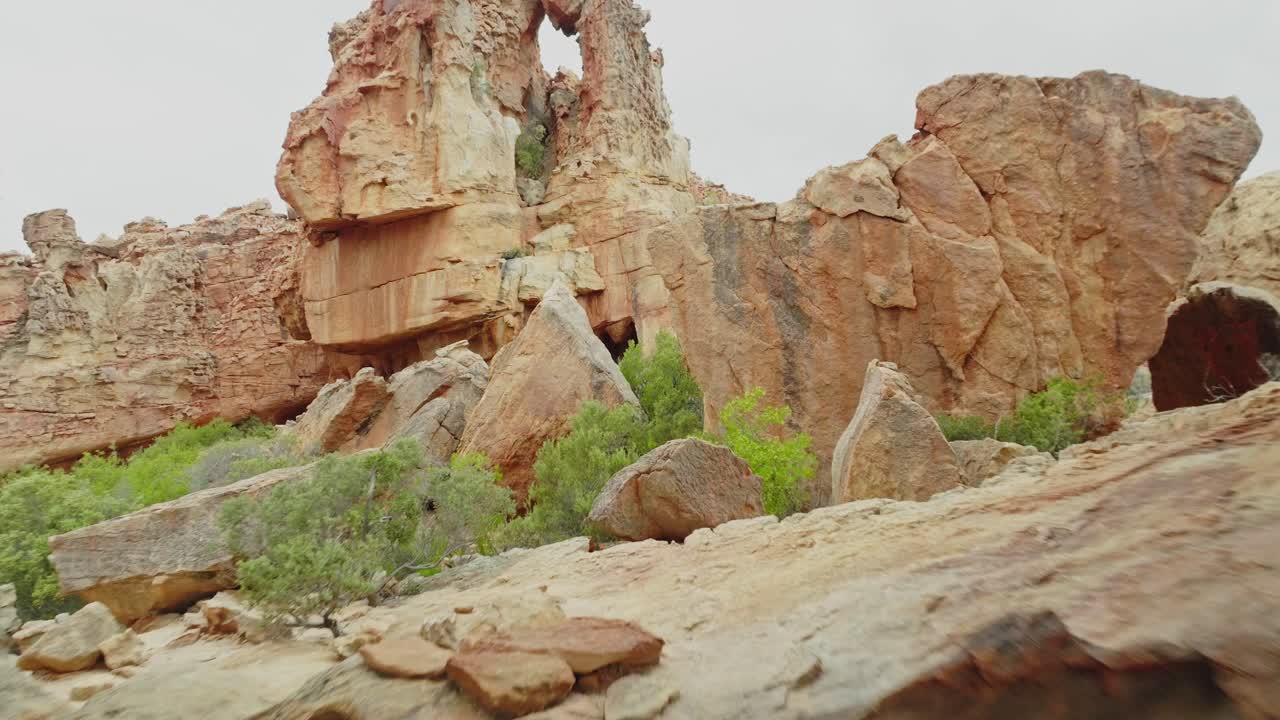 드론은 남아프리카 공화국의 세더버그 야생 지역의 바위 형성의 구을 천천히 날아갑니다.
