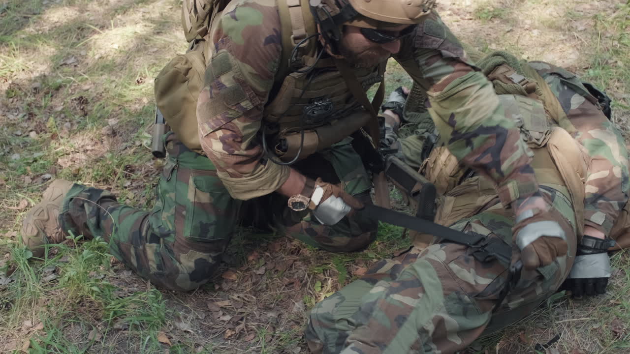 Applying Tourniquet To Soldier Wounded Leg