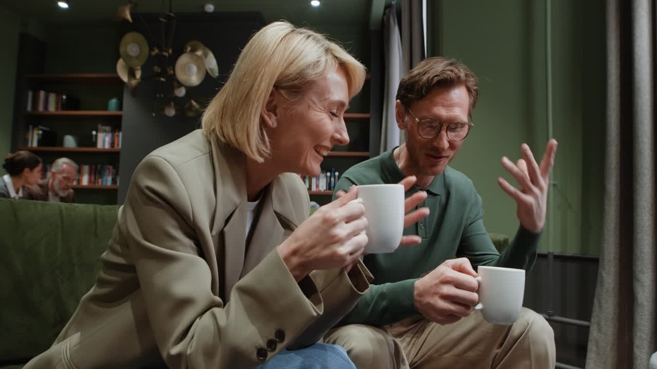 Two people having a relaxed conversation over coffee in a lounge