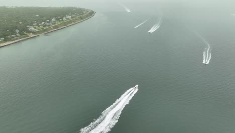 drone shot of powerboats traveling along the coast of massachusetts