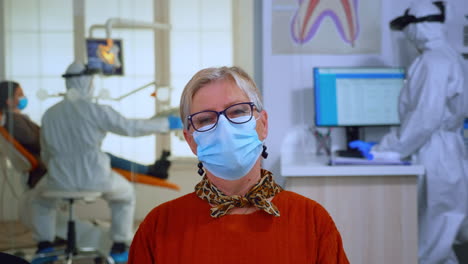 portrait of retired patient with mask in dental office looking on camera