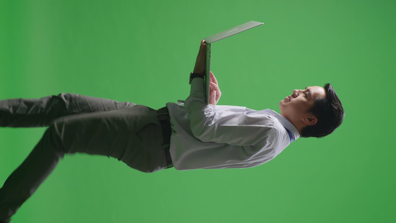 남자가 비정상적인 자세로 노트북을 들고 있다