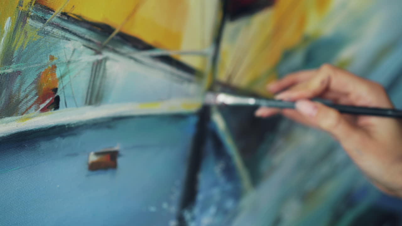 Close-up of a hand painting abstract art on canvas