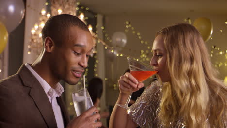couple make toast as they celebrate at party together