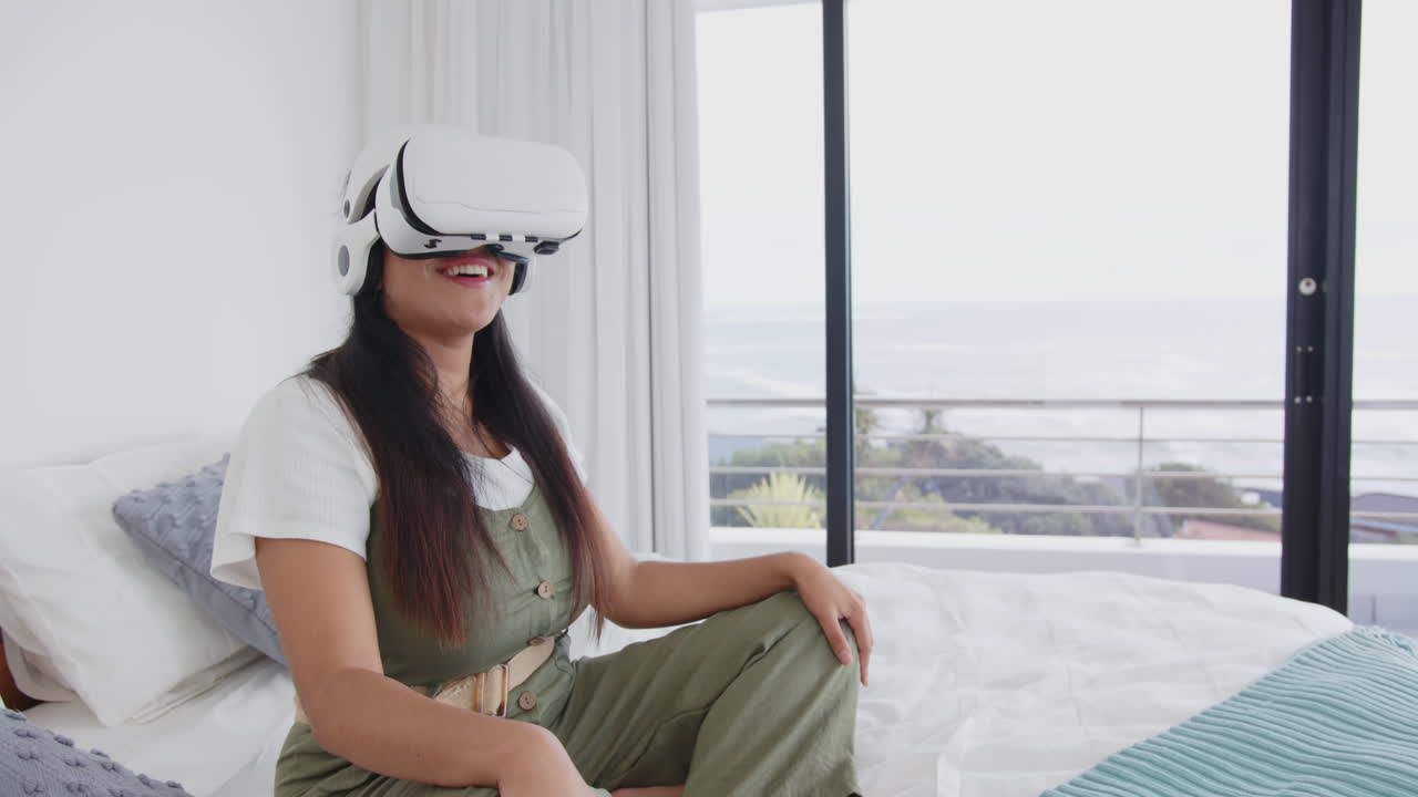 Using VR headset, asian woman relaxing on bed in modern spa setting, at home