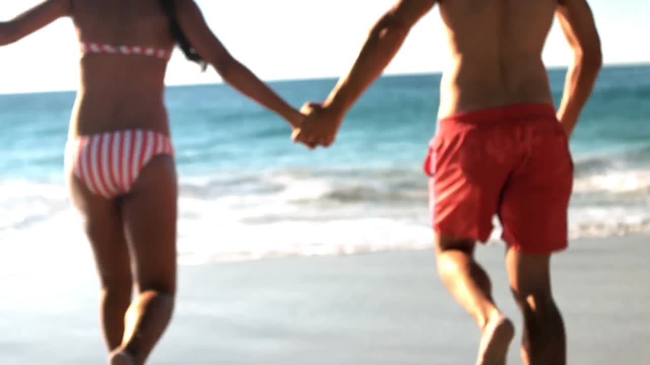 pareja corriendo en la playa
