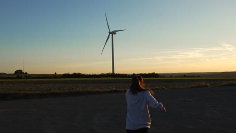 female woman jumping, express happiness, positive energy in wind turbine field