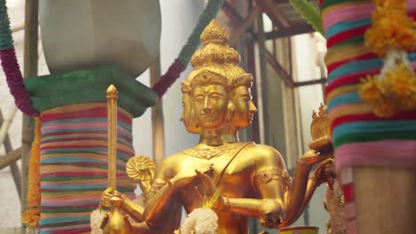 closeup shot of golden statue sculpture of brahma phra phrom 4 faced god in hindu and buddhism around colorful temple, hinduism religious atmosphere