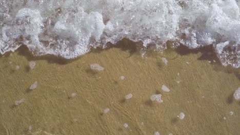 vista superior de las pequeñas olas del océano que van y vienen - tiro estático en cámara lenta