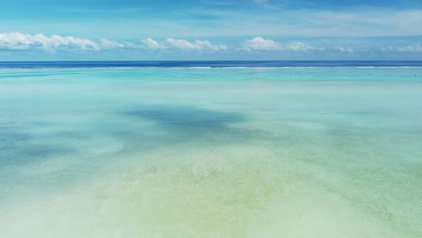 tropical sand flats at the edge of a barrier reef with the ocean in view