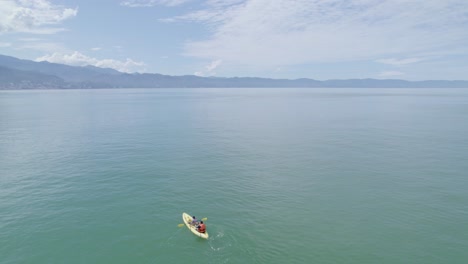 Two-people-paddling-a-kayak-on-the-beach