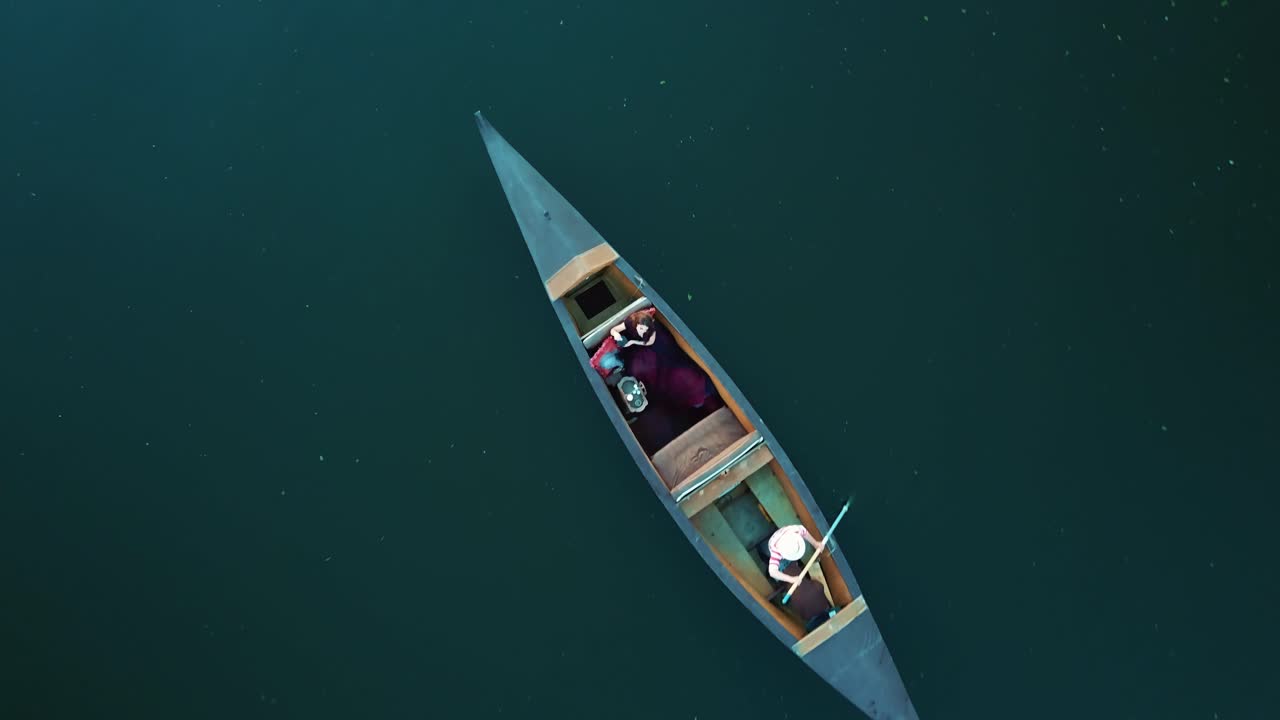 Aerial view woman traveling by boat at sunset. Gondola floating along the river