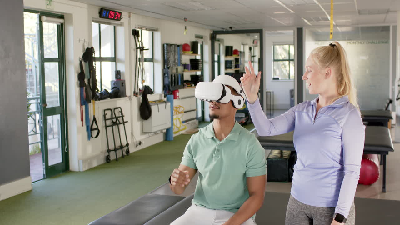 Using VR headset, man in rehabilitation with therapist guiding in gym