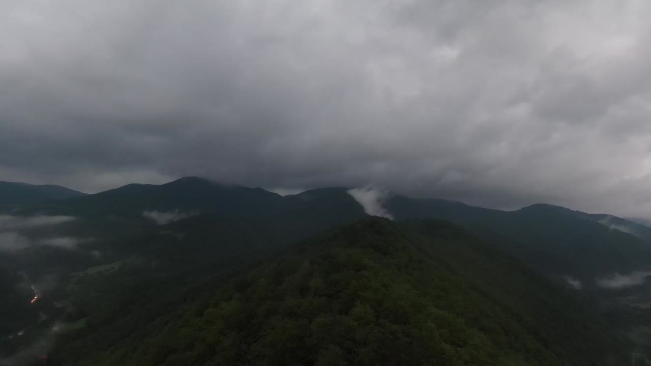 태국 북부 도이푸카산 보호 국립공원의 장마철에 비구름이 덮힌 무성한 녹색 열대 우림 산 위를 날아가는 공중 전망