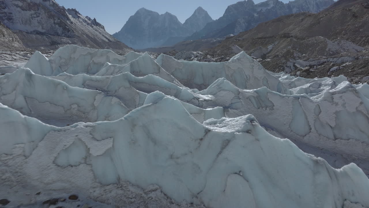 Luftfoto fra drone som viser et smeltende istårn dannet på Khumbu-breen i middagssolens lys, omgitt av Everest-fjellkjeden i Everest-regionen Himalaya, Nepal.