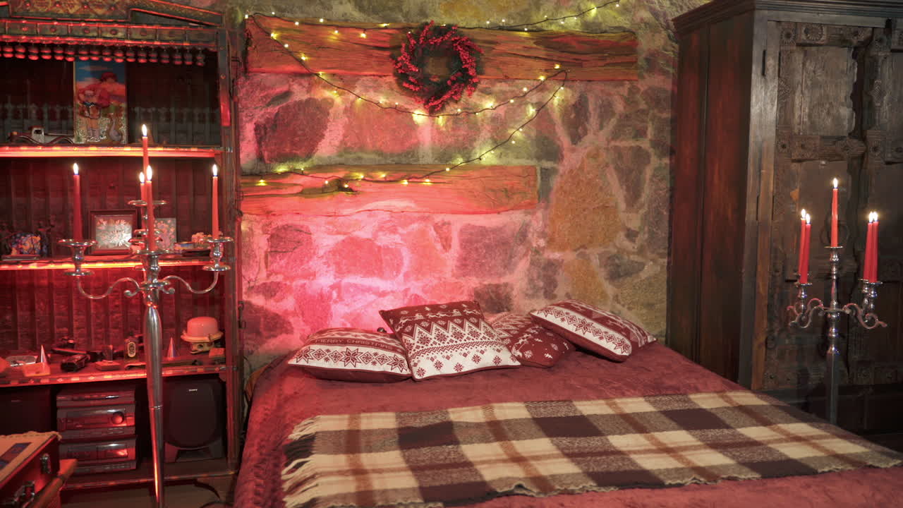 Empty bedroom with candles. Decorated room in pink romantic colors with bed. Christmas decorations in the room. Cosy atmosphere.