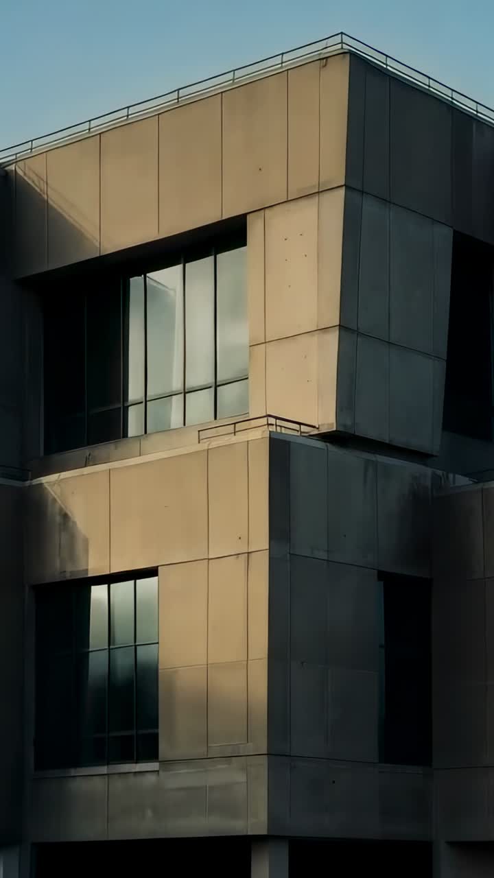 Vídeo vertical: Câmera começando a recuar em canto de concreto urbano, mostrando formas escalonadas e painéis de vidro