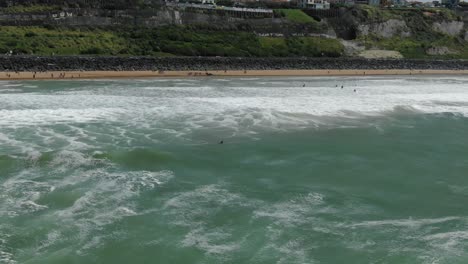 lone surfer on surfboard waiting for waves in ocean, biarritz, france. aerial drone lateral view