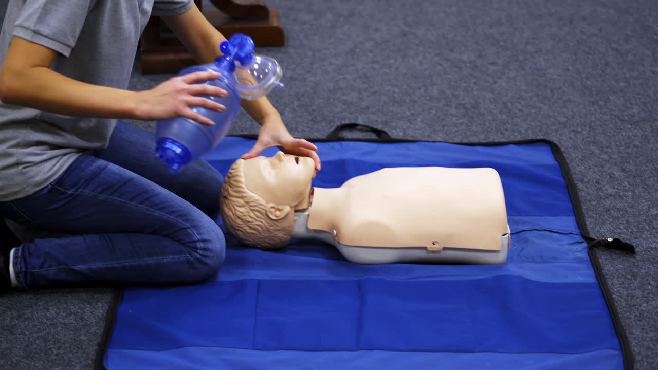 Training session for saving life. Instructor shows cardiac exercise on a mannequin. Demonstration of cpr on a dummy with breathing apparatus.