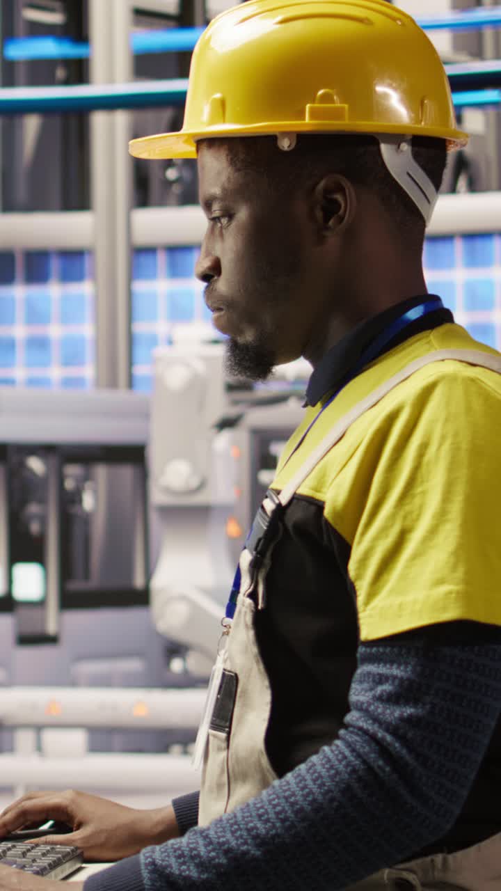 Vertical video Smart factory employee typing on PC keyboard, testing automated systems