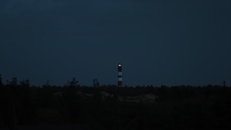 darkness descended, in distance lighthouse sends it’s signal out to sea