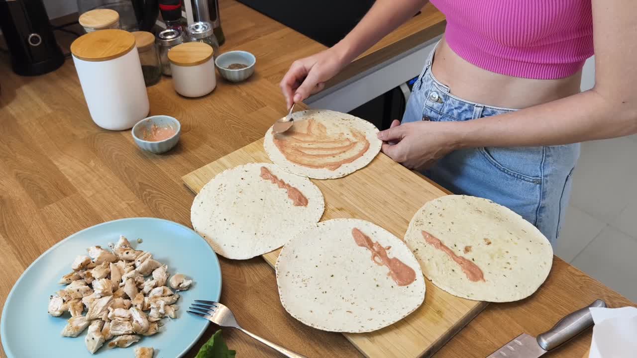 mujer preparando envolturas de pollo