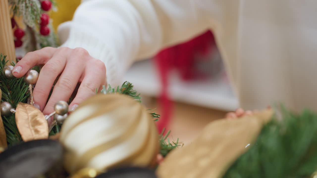 Close-up of elegant lady gently touching decorative Christmas plant in a festive store, Christmas decor, golden ornaments, and holiday spirit fill the vibrant scene with warmth and joy
